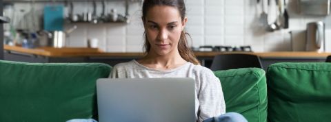 Ces documentaires qui nous font changer de vie Une femme qui regarde son écran d'ordinateur assise sur son canapé
