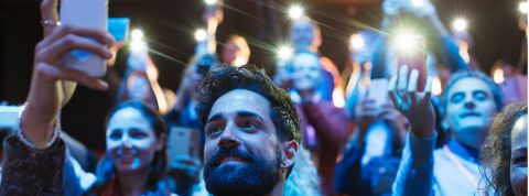 Nous sommes tous accros à nos smartphones mais c'est à cause de la captologie Une foule de gens tenant leurs smartphones