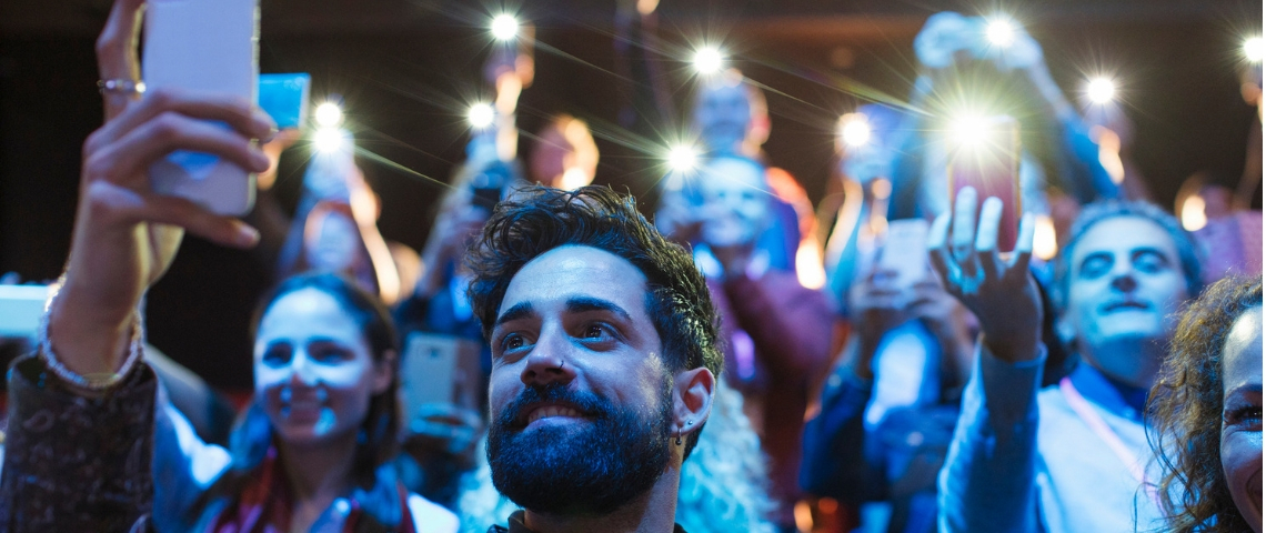 Nous sommes tous accros à nos smartphones mais c'est à cause de la captologie Une foule de gens tenant leurs smartphones