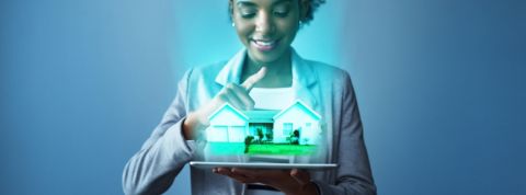 La technologie redéfinit le futur de l'immobilier Une femme en train de visualiser une maison en réalité augmentée