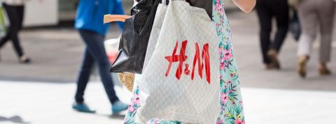 En 2019, la fast fashion se porte bien Une femme avec un sac en plastique H&M