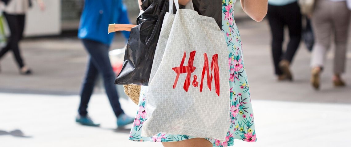 En 2019, la fast fashion se porte bien Une femme avec un sac en plastique H&M