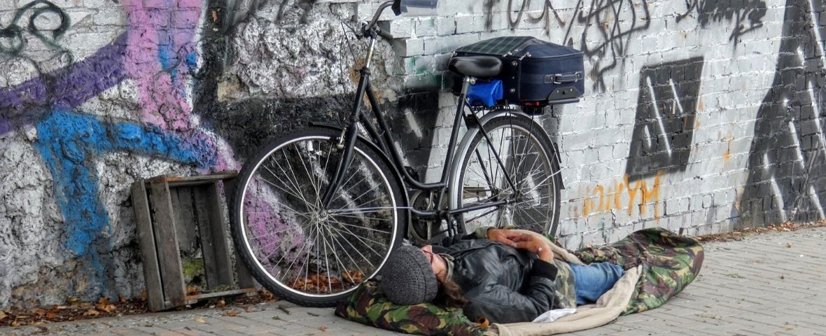lilo-moteur-recherche-offrir-cadeau-noel-solidaire-sans-abris SDF dormant au sol, à côté de son vélo