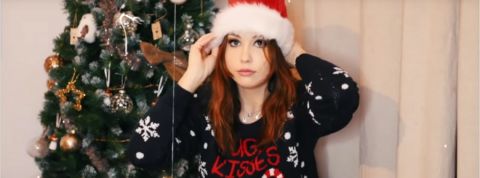 Les vlogmas une jeune fille avec un chapeau de Noël et un sapin