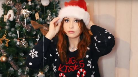 une jeune fille avec un chapeau de Noël et un sapin