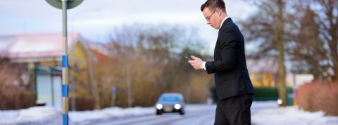 Regarder trop son smartphone fait mal (littéralement) Homme traversant la route en regardant son smartphone