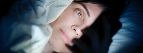 Tinder compte des agresseurs sexuels reconnus parmi ses utilisateurs Une femme regarde son smartphone dans son lit