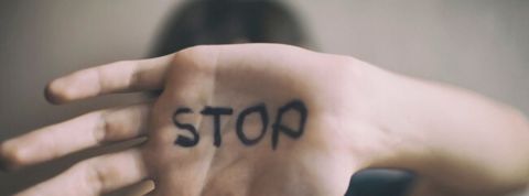 Microsoft se lance dans la traque des pédophiles un enfant montre la paume de sa main où est écrit en noir le mot stop