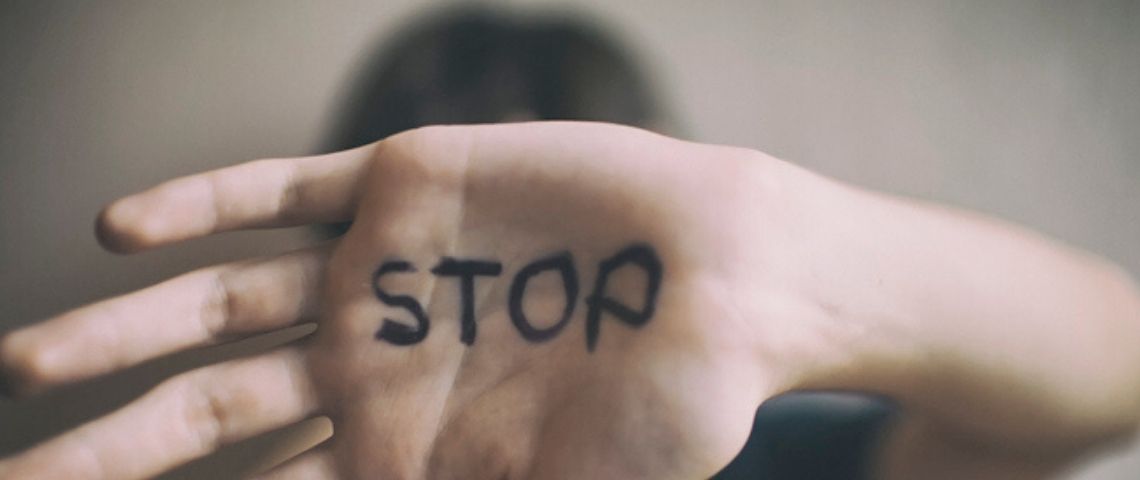 Microsoft se lance dans la traque des pédophiles un enfant montre la paume de sa main où est écrit en noir le mot stop