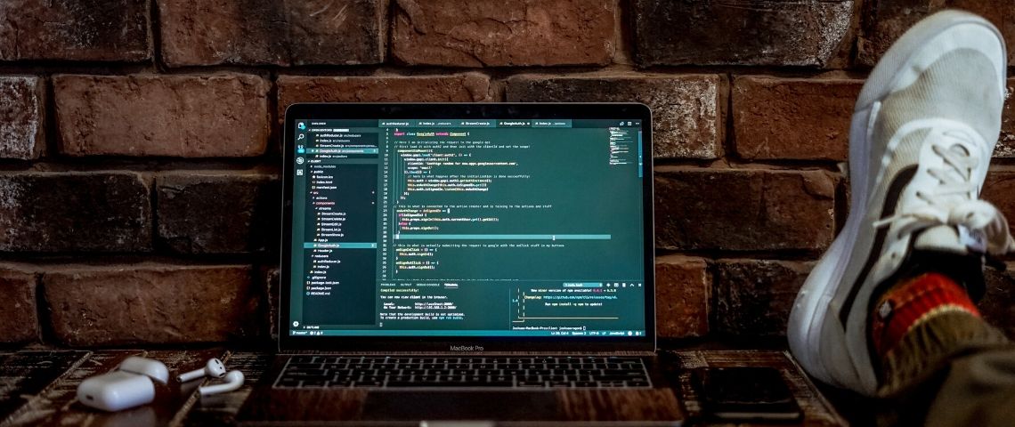 Elon musk récompense ses hackers. Un ordinateur posé sur un bureau et ouvert sur des lignes de code.
