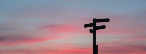 Et si la responsabilité était l’opportunité de penser notre futur ? Des panneaux directionnels sur fond de ciel rosé