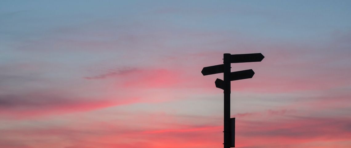 Et si la responsabilité était l’opportunité de penser notre futur ? Des panneaux directionnels sur fond de ciel rosé