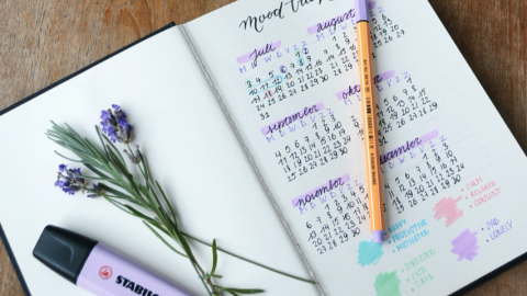 un carnet aux pages blanches ouvertes sur une table de bois avec un stabilisateur violet