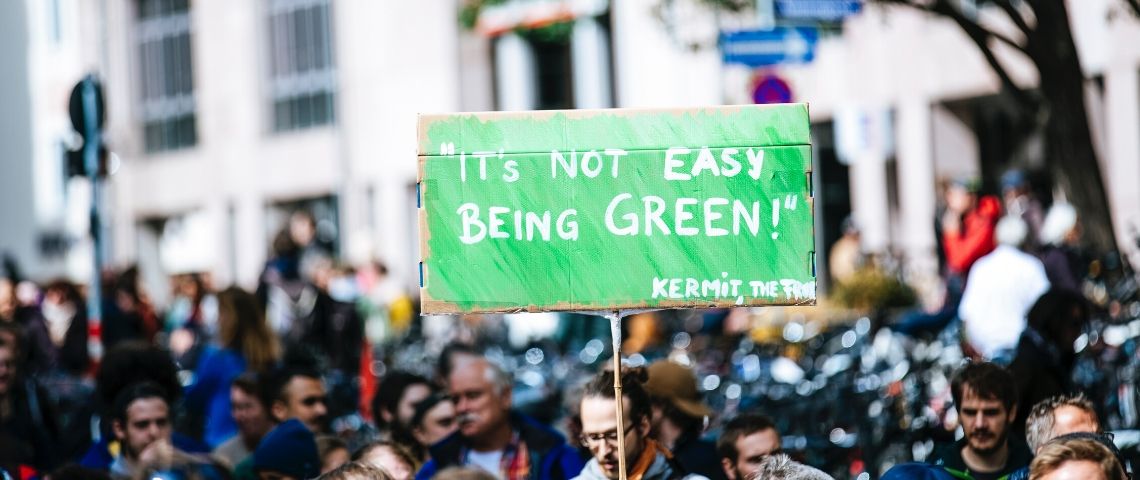 Total assigné en justice pour inaction climatique Une pancarte - it's not easy being green -