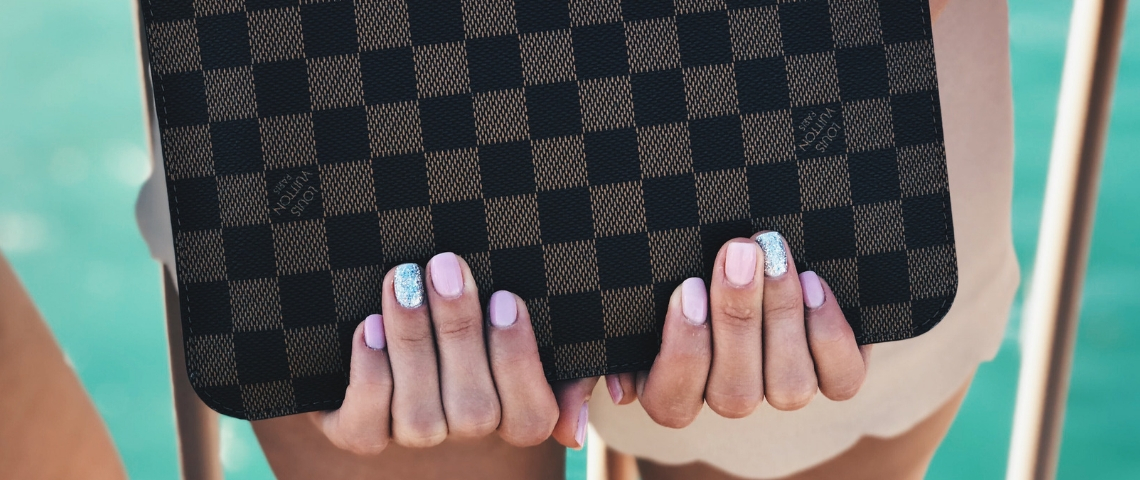 Quelles sont les meilleures marques françaises ? Une jeune femme tenant un sac Louis Vuitton