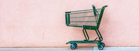Les chiffres de la consommation en 2019 Un chariot de supermarché vert abandonné devant un mur rose