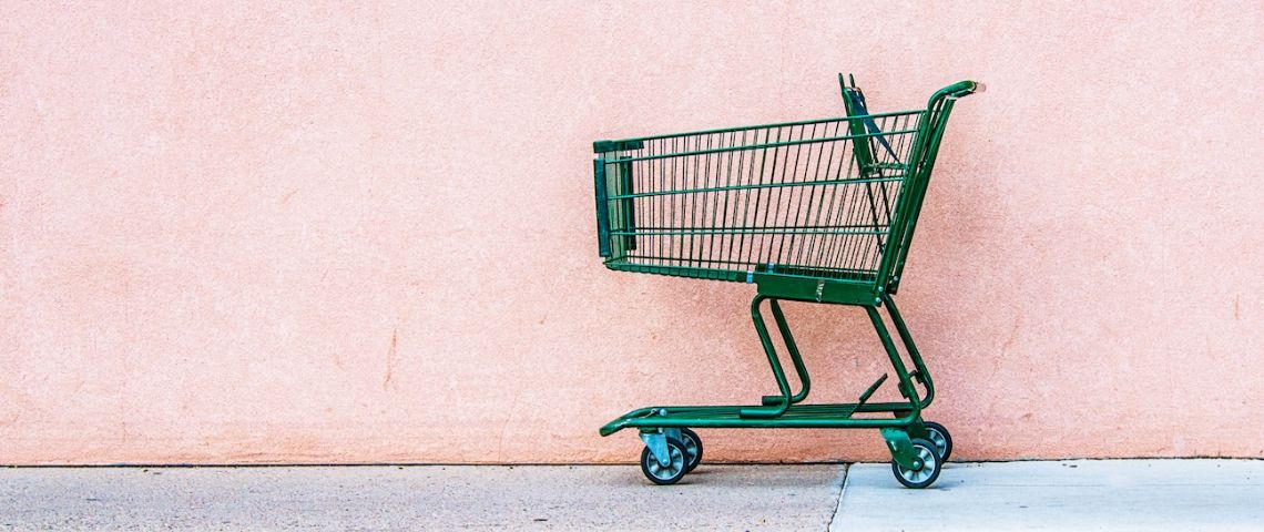 Les chiffres de la consommation en 2019 Un chariot de supermarché vert abandonné devant un mur rose