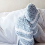 Une paire de pieds avec des chaussettes dans un lit