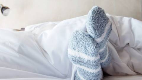 Une paire de pieds avec des chaussettes dans un lit