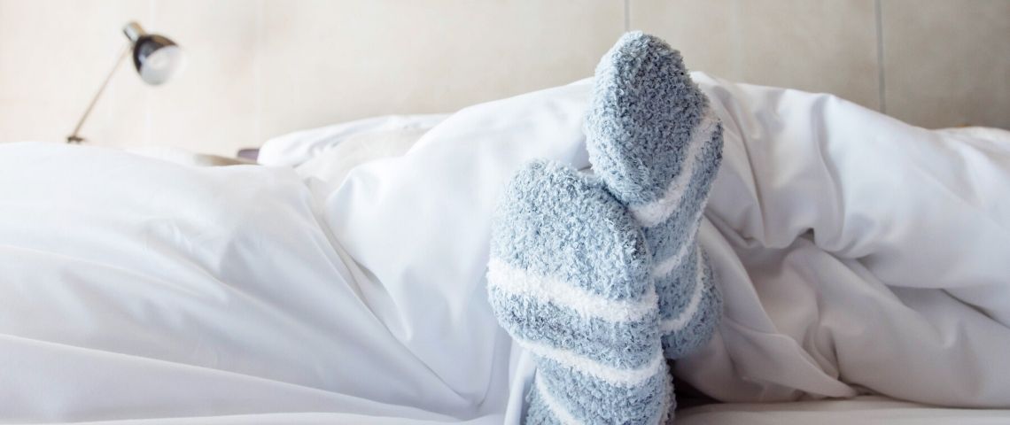 La génération Z passe ses nuits sur Skype Une paire de pieds avec des chaussettes dans un lit