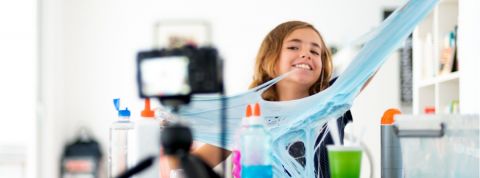 Les enfants sur YouTube sont-ils plus protégés ? une jeune fille joue avec du slime face caméra.