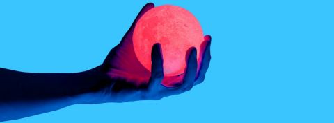 Qu'est-ce que la technologie haptique ? Une main sur fond bleu en train de tenir une boule lumineuse