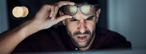 Trop d'indignation sur Twitter un homme fronce les sourcils et lève ses lunettes en regardant un écran.