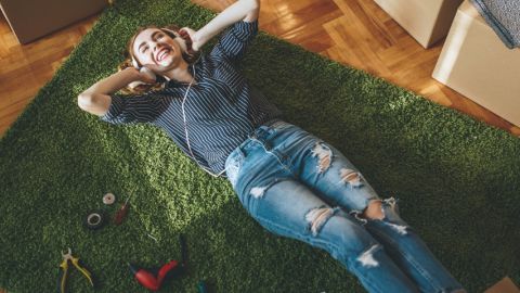 Interface : comment devenir une marque écolo ?  Une jeune femme allongée sur de la moquette imitant de l'herbe