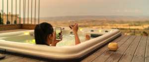 une influenceuse dans un bain qui prend en photo son verre de vin
