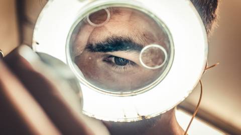 un homme regarde dans une loupe lumineuse