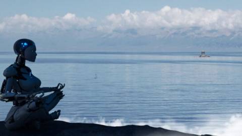 Un robot médite sur une plage devant la mer