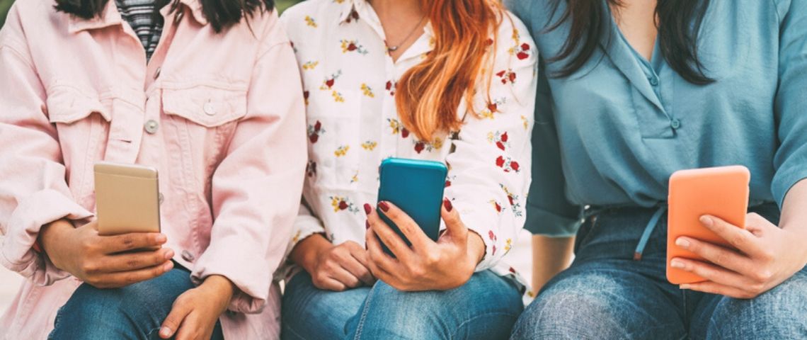 Comment mieux contrôler ses données facebook Trois femmes assises tiennent leur téléphone portable