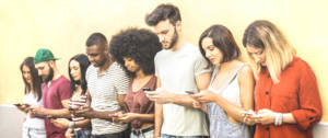 une groupe de jeune gens qui regardent leur portable.