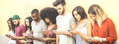 Améliorer YouTube, c'est possible une groupe de jeune gens qui regardent leur portable.