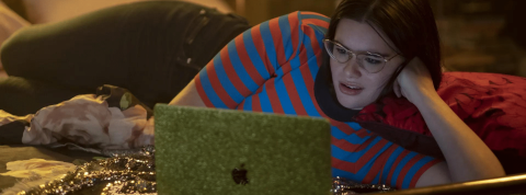 Pas l'euphorie pour les nudes Une jeune fille brune allongée sur un lit devant un ordi