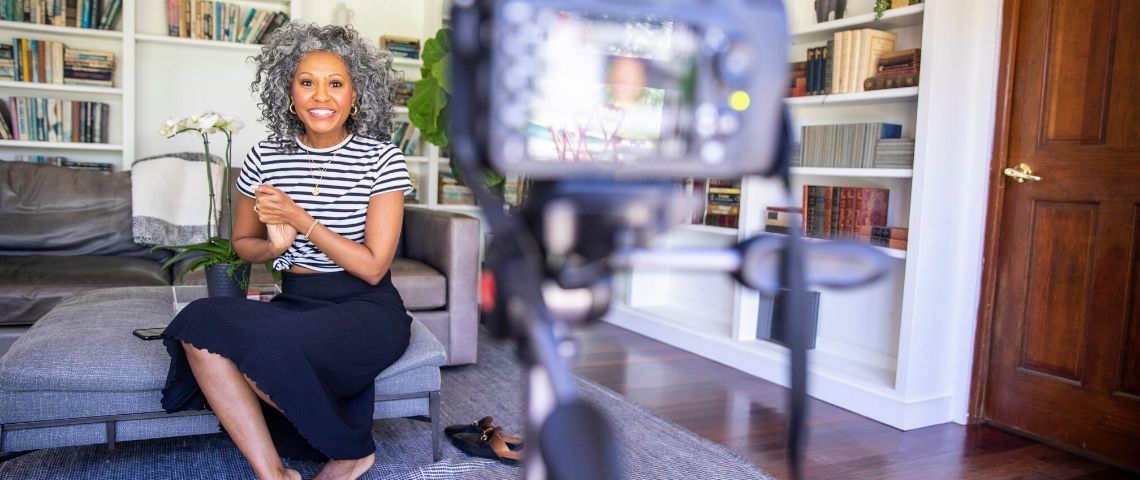 Influenceurs en quête d’une nouvelle reconnaissance Une femme métisse souriante devant une caméra, influence