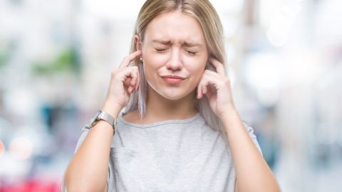 Une femme qui se bouche les oreilles