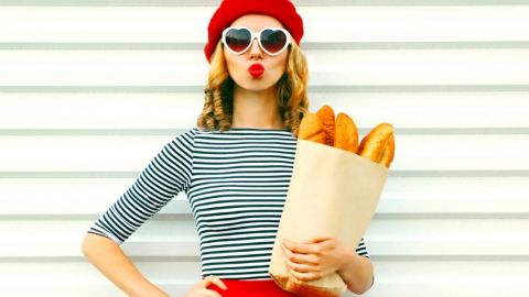 Une femme avec une marinière, un béret et des baguettes de pain