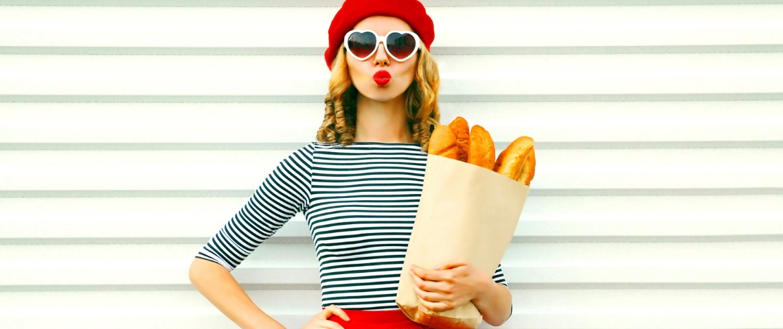 Que veulent manger les Français ? Une femme avec une marinière, un béret et des baguettes de pain