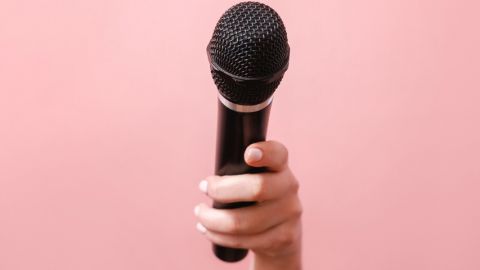 Une main de femme tendant un micro