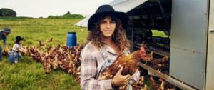 Une agricultrice avec un poulet dans les bras