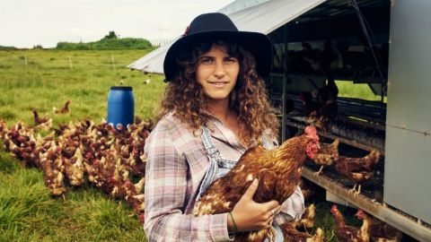 Une agricultrice avec un poulet dans les bras