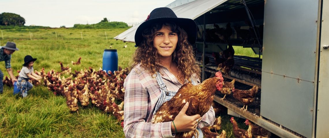 Comment changer l'image des agriculteurs ? Une agricultrice avec un poulet dans les bras
