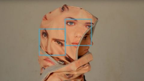 une capuche avec des visages pour se protéger de la reconnaissance faciale