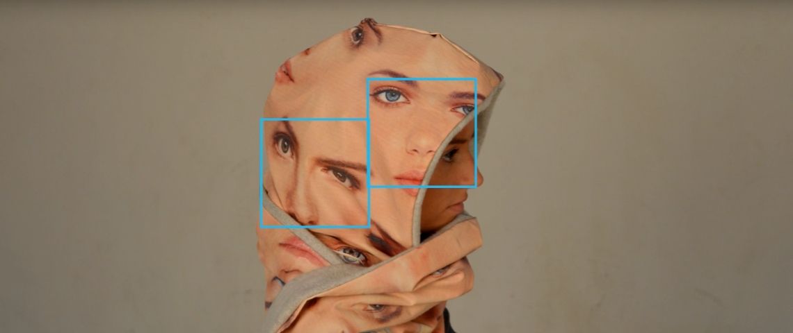 « Souriez, vous êtes filmé » : comment les artistes nous alertent sur la reconnaissance faciale une capuche avec des visages pour se protéger de la reconnaissance faciale