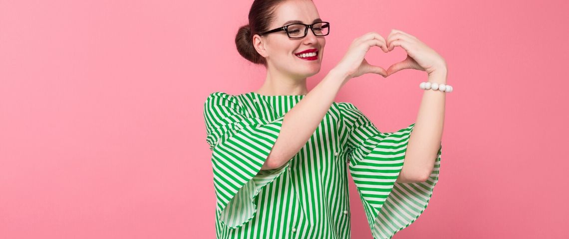 Comment une marque peut acquérir le statut de love brand... et le garder ? Une femme fait un coeur avec ses doigts