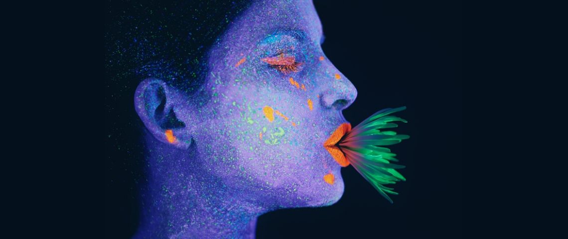 Comment penser notre rapport au végétal ? Une femme au visage bleu avec une plante verte dans la bouche