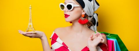 La Fashion Week consomme autant que l'éclairage de la Tour Eiffel pendant 3 000 ans Une femme avec un foulard et des lunettes qui tient un Tour Eiffel dans sa main