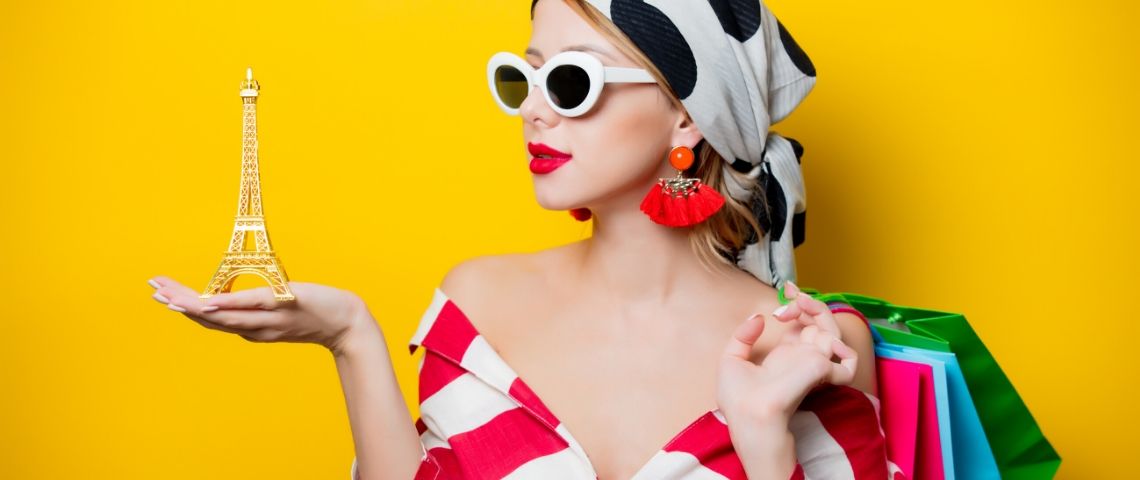 La Fashion Week consomme autant que l'éclairage de la Tour Eiffel pendant 3 000 ans Une femme avec un foulard et des lunettes qui tient un Tour Eiffel dans sa main