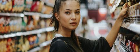 Quelles sont les tendances de la distribution ?  Une femme en train de choisir des produits dans les rayons d'un supermarché